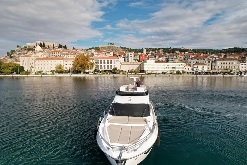  Yacht Photos Pics 2024 Azimut Fly 53 yacht cruising near a picturesque coastal town.