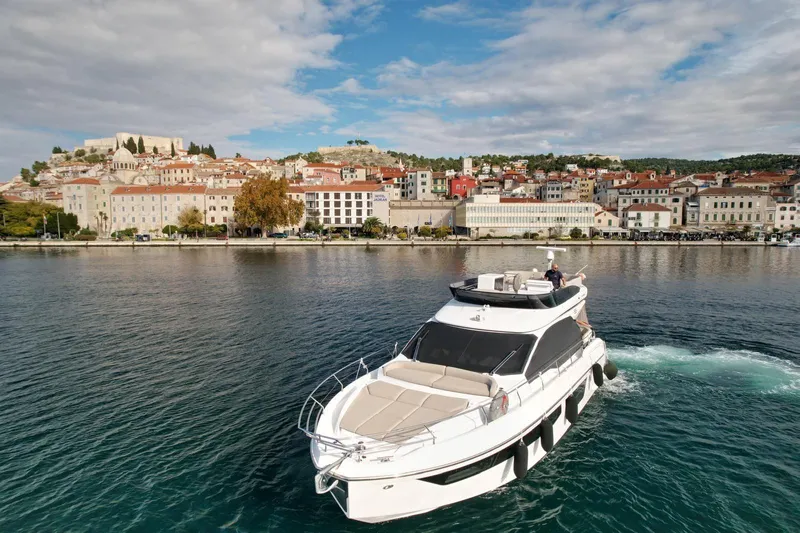  Yacht Photos Pics 2024 Azimut Fly 53 yacht cruising near a picturesque coastal town.