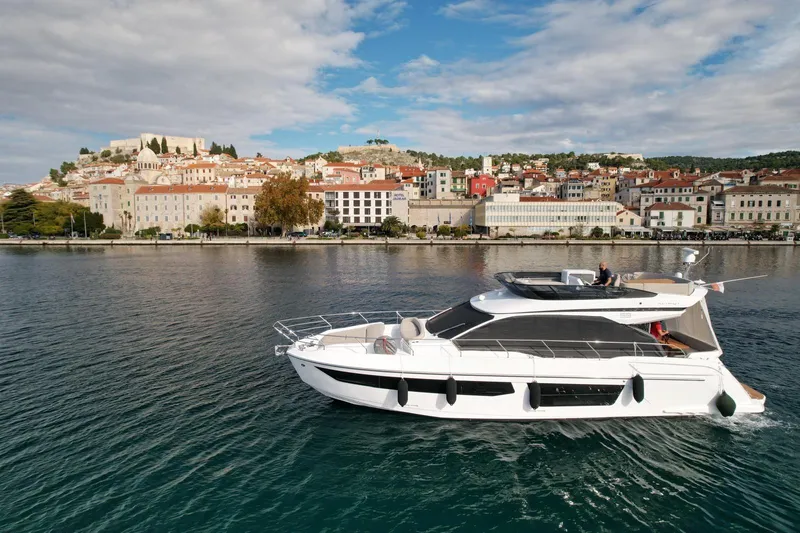  Yacht Photos Pics 2024 Azimut Fly 53 yacht cruising near a picturesque coastal town.