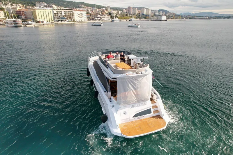  Yacht Photos Pics 2024 Azimut Fly 53 yacht cruising near a coastal cityscape.