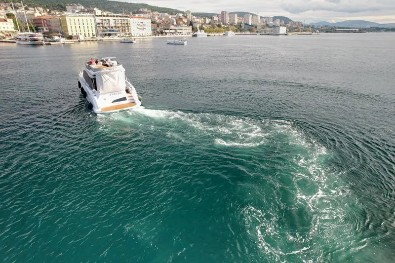  Yacht Photos Pics 2024 Azimut Fly 53 yacht cruising in a scenic coastal city harbor.