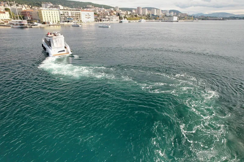  Yacht Photos Pics 2024 Azimut Fly 53 yacht cruising near coastal cityscape.