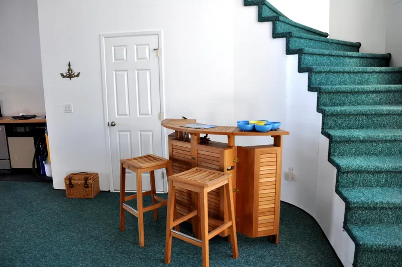  Yacht Photos Pics Cozy interior of 2004 Steelhead Marine Boat House with wooden bar and green carpeted stairs.
