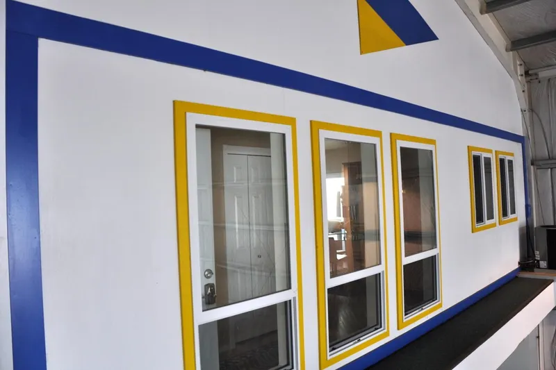  Yacht Photos Pics Steelhead Marine Boat House 2004 with blue and yellow trim, featuring multiple windows.