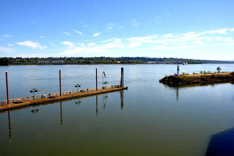  Yacht Photos Pics Calm river view with dock and lighthouse, featuring Steelhead Marine Boat House, 2004.