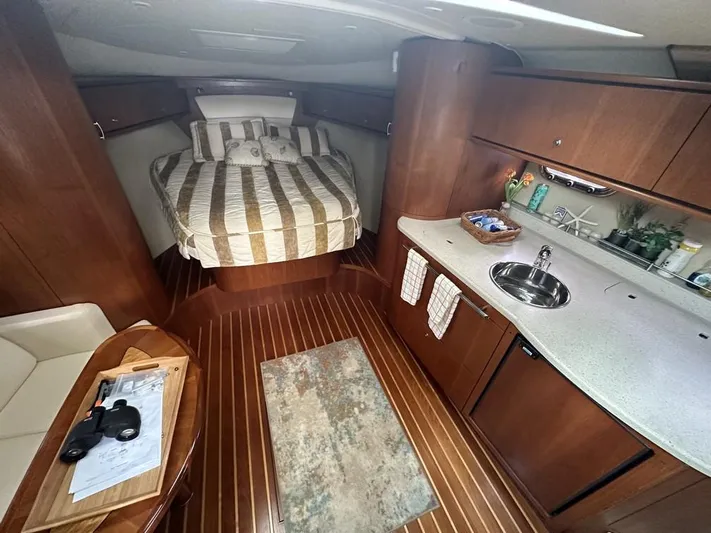 2008 Tiara 3500 Sovran Yacht Photos Pics 2008 Tiara Yachts 3500 Sovran interior with bed, kitchenette, and wooden flooring.