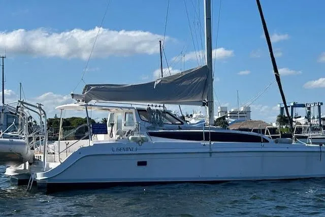 Rockstar Yacht Photos Pics Sailing catamaran Gemini Legacy 2013 on water, clear sky, marina background.