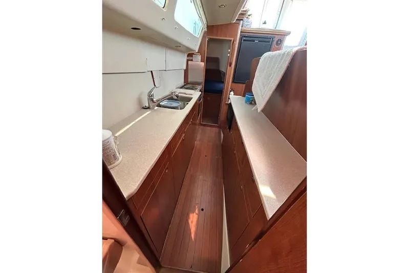 Rockstar Yacht Photos Pics Interior of 2013 Gemini Legacy boat featuring a compact kitchen with wooden cabinetry.