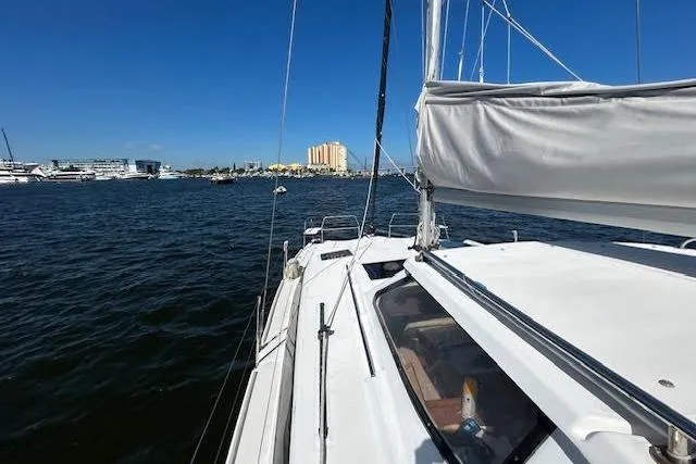 Rockstar Yacht Photos Pics Sailboat on water, Gemini Legacy 2013, with cityscape in background under clear blue sky.