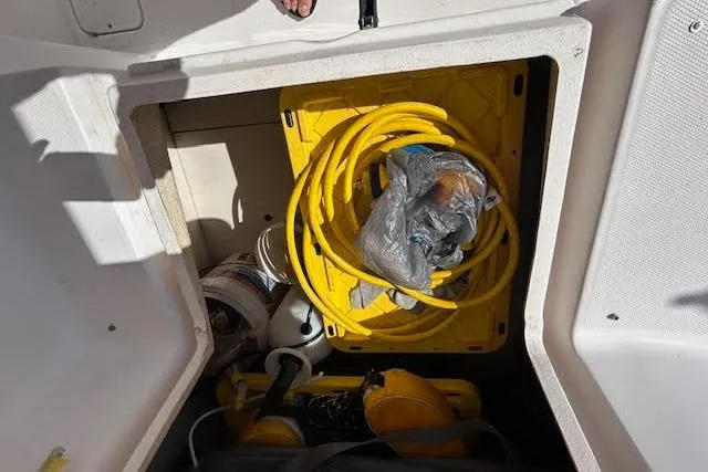 Rockstar Yacht Photos Pics Storage compartment in 2013 Gemini Legacy boat with yellow hose and equipment.
