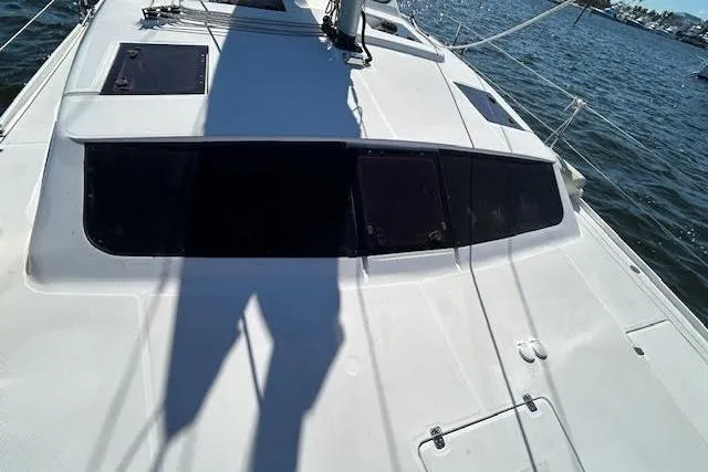 Rockstar Yacht Photos Pics 2013 Gemini Legacy sailboat deck with shadow, on calm water.