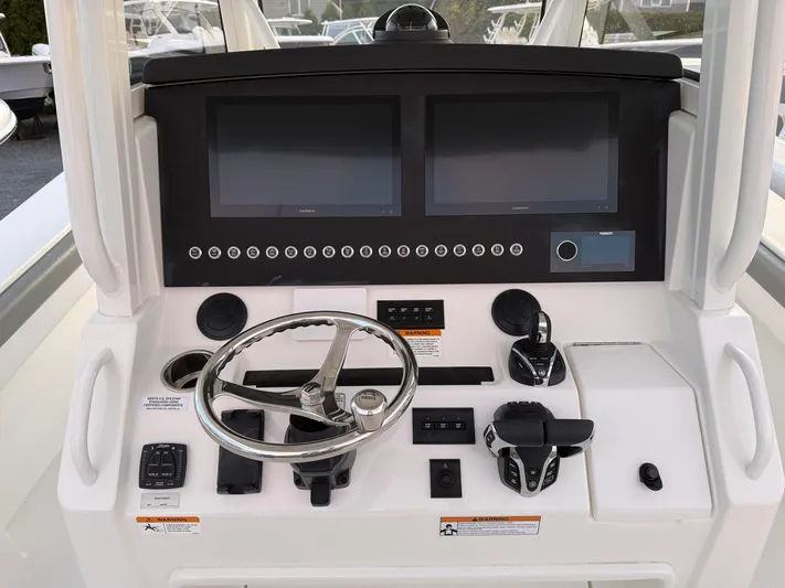 White Yacht Photos Pics 2024 Regulator 34 boat dashboard with dual screens and steering wheel.