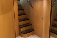 Interior staircase of 2008 Pershing 90 yacht with wooden paneling and modern lighting.