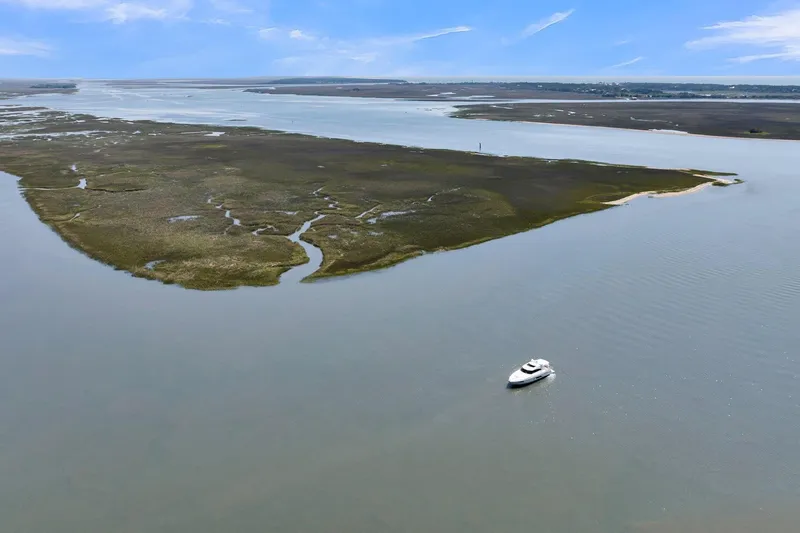  Yacht Photos Pics Aerial view of 2020 Riviera 4800 Sport Yacht cruising near coastal wetlands.