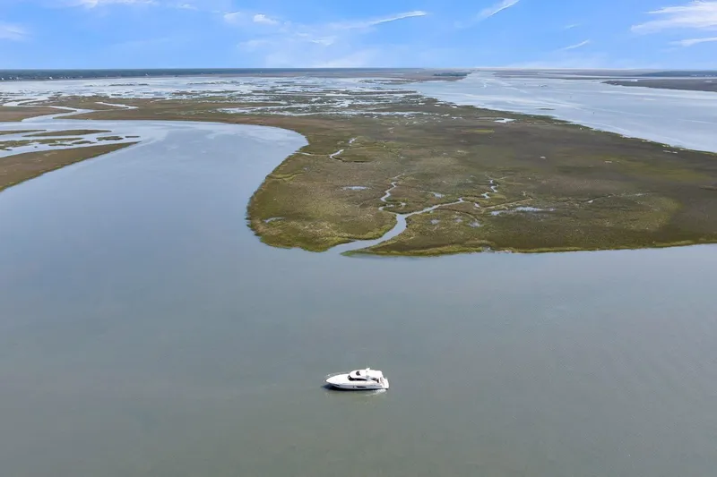  Yacht Photos Pics Aerial view of 2020 Riviera 4800 Sport Yacht on calm waters near marshland.