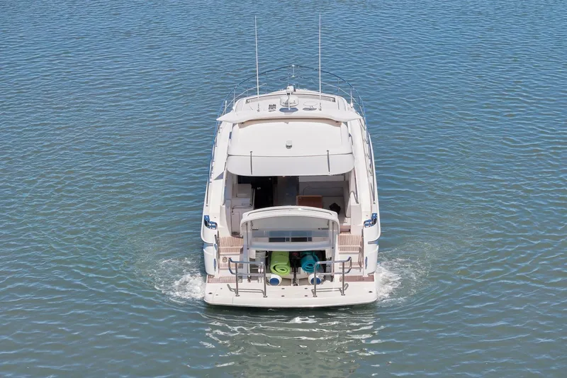  Yacht Photos Pics Riviera 4800 Sport Yacht 2020 cruising on calm blue waters, rear view.