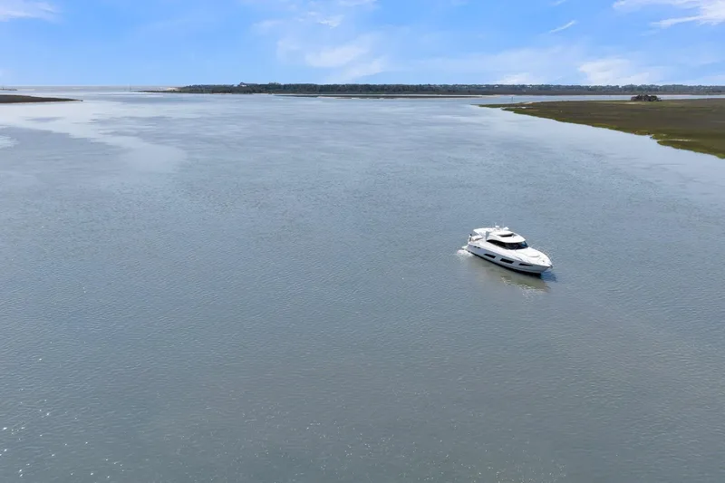  Yacht Photos Pics 2020 Riviera 4800 Sport Yacht cruising on a serene, expansive waterway.