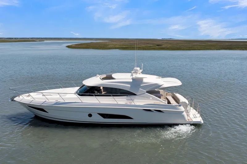  Yacht Photos Pics 2020 Riviera 4800 Sport Yacht cruising on calm waters under a clear blue sky.