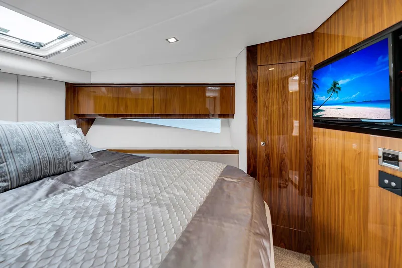  Yacht Photos Pics Luxurious interior of 2020 Riviera 4800 Sport Yacht with elegant wood finishes and cozy bedding.