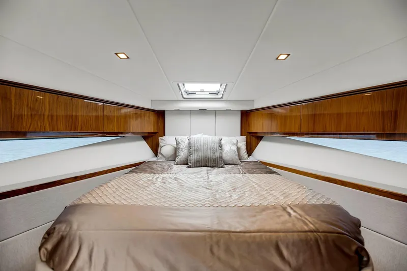  Yacht Photos Pics Luxurious bedroom interior of 2020 Riviera 4800 Sport Yacht with elegant wood finishes.
