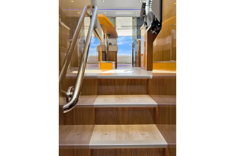  Yacht Photos Pics Interior stairs of 2020 Riviera 4800 Sport Yacht, featuring sleek wood finish and modern design.