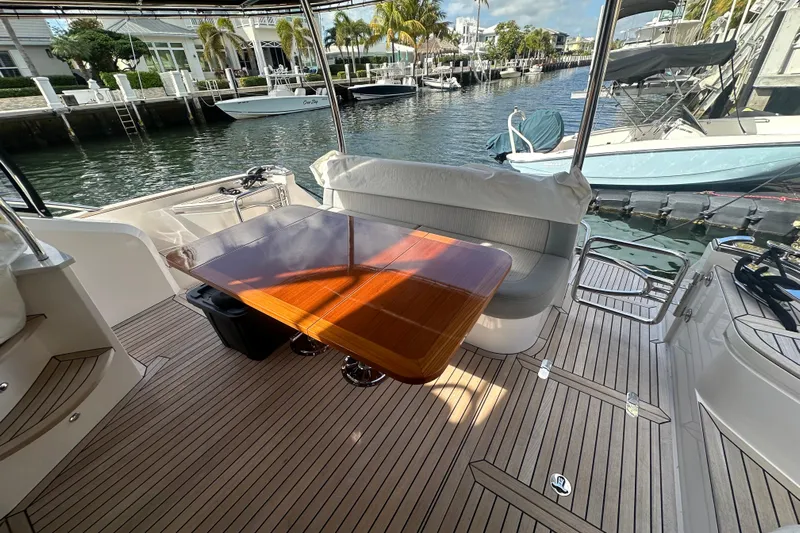 Our Trade Yacht Photos Pics Luxurious Belize 54 Day Bridge yacht interior, featuring elegant wood table and waterfront view, 2023 model.