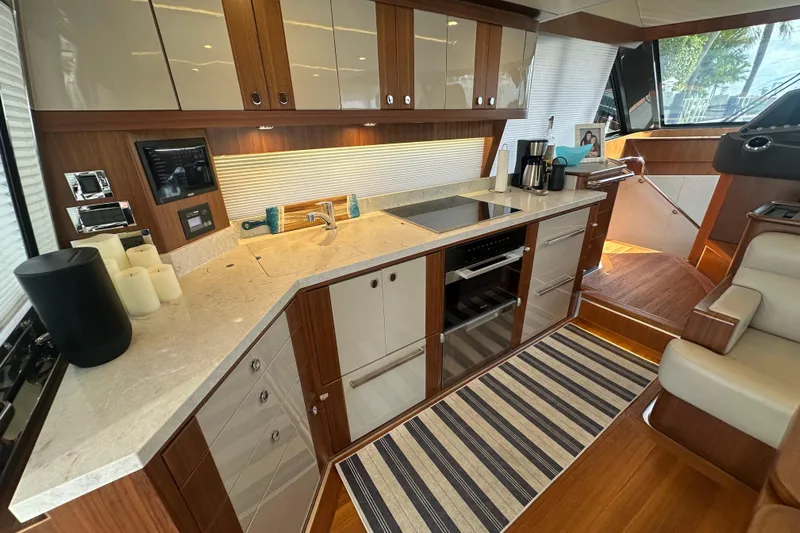 Our Trade Yacht Photos Pics Luxurious kitchen interior of 2023 Belize 54 Day Bridge yacht with modern appliances and wood finish.