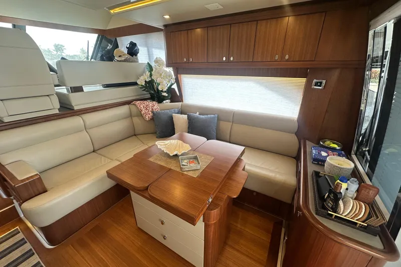 Our Trade Yacht Photos Pics Luxurious interior of 2023 Belize 54 Day Bridge yacht with elegant seating and wooden finishes.