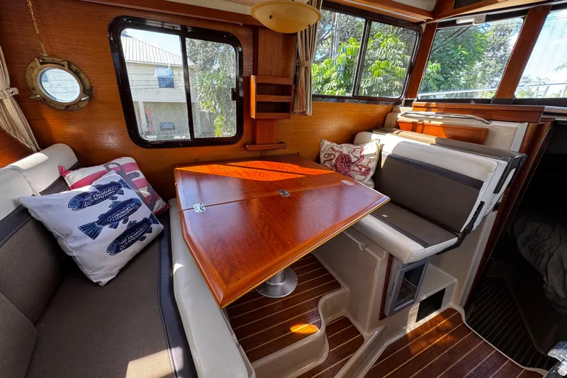 My Backyard Yacht Photos Pics 2014 Ranger Tugs R-31 CB interior with wooden table, cushioned seating, and nautical decor.