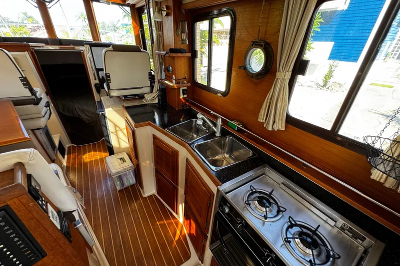My Backyard Yacht Photos Pics 2014 Ranger Tugs R-31 CB interior with kitchen, stove, and seating area.