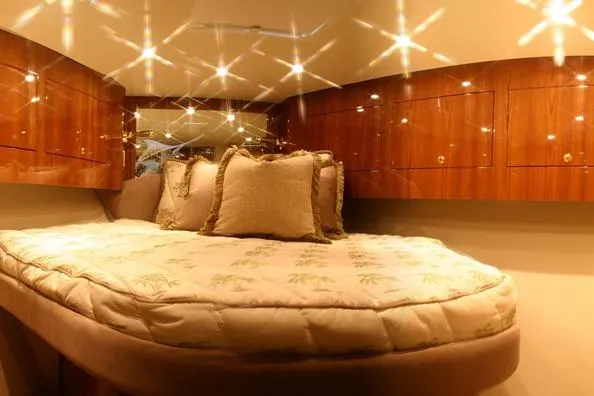  Yacht Photos Pics Luxurious cabin interior of 2026 Buddy Davis 58 Sportfisherman with plush bedding and wood cabinetry.