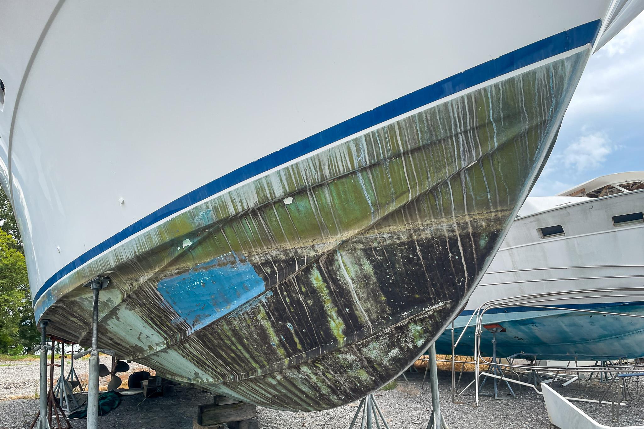 1978 Bertram 46 Convertible boat hull with weathered paint, on dry dock.