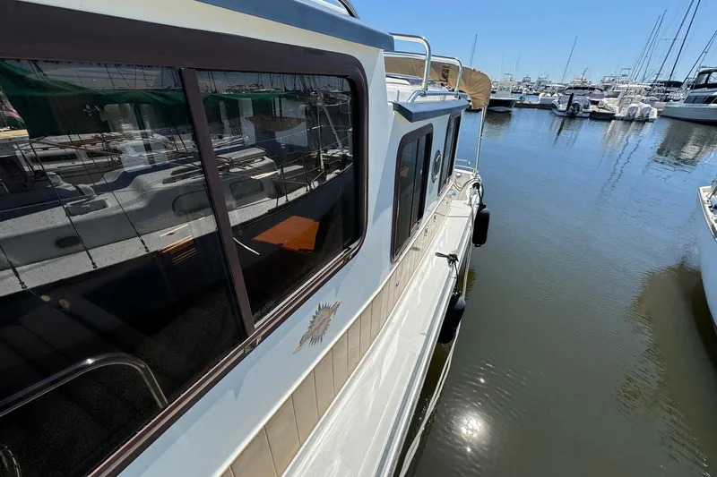 Point Aft'r Yacht Photos Pics 2012 Ranger Tugs R-29 docked at marina, reflecting on calm water.