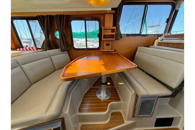 Point Aft'r Yacht Photos Pics Interior of 2012 Ranger Tugs R-29 with wooden table and cushioned seating.