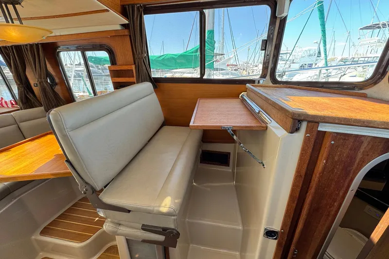 Point Aft'r Yacht Photos Pics Interior of 2012 Ranger Tugs R-29 boat with seating and wooden table.