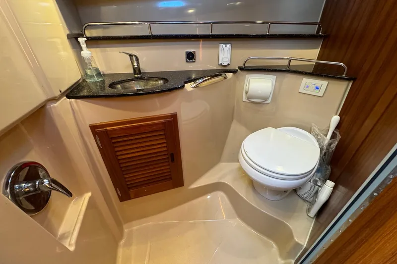 Point Aft'r Yacht Photos Pics 2012 Ranger Tugs R-29 bathroom with sink, toilet, and wooden cabinet.