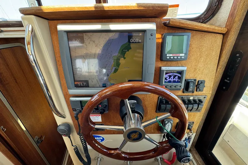Point Aft'r Yacht Photos Pics 2012 Ranger Tugs R-29 helm with navigation screens and wooden steering wheel.