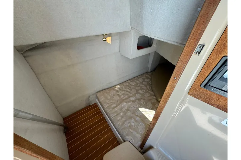 Point Aft'r Yacht Photos Pics Cozy cabin interior of 2012 Ranger Tugs R-29 with cushioned bed and wooden accents.