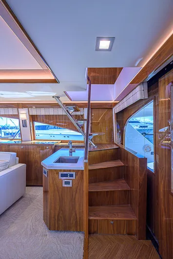 Bella Yacht Photos Pics Luxurious interior of 2018 Viking 92 Sky Bridge yacht with wooden stairs and modern design.