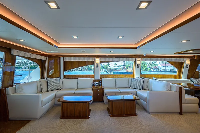 Bella Yacht Photos Pics Luxurious interior of 2018 Viking 92 Sky Bridge yacht with white sofas and wooden accents.