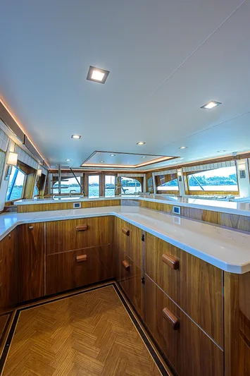 Bella Yacht Photos Pics Luxurious interior of 2018 Viking 92 Sky Bridge yacht with wooden cabinetry and panoramic windows.