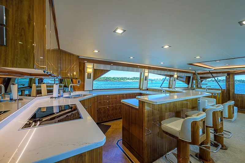 Bella Yacht Photos Pics Luxurious interior of 2018 Viking 92 Sky Bridge yacht with modern kitchen and ocean view.