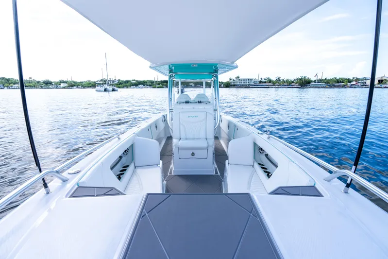  Yacht Photos Pics 2024 Dynamic D-305V boat interior with white seating and canopy on a calm lake.