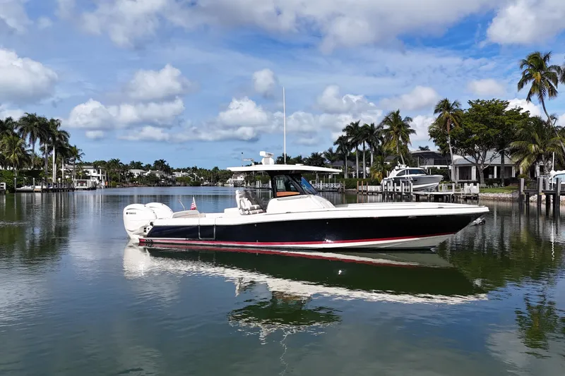  Yacht Photos Pics 2020 Chris-Craft Catalina 34 boat on calm water, surrounded by palm trees and luxury homes.