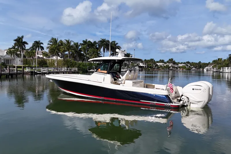  Yacht Photos Pics 2020 Chris-Craft Catalina 34 boat on calm water, surrounded by palm trees and luxury homes.