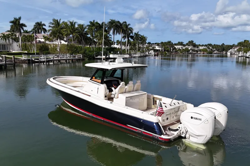  Yacht Photos Pics 2020 Chris-Craft Catalina 34 boat on calm water, surrounded by palm trees and luxury homes.