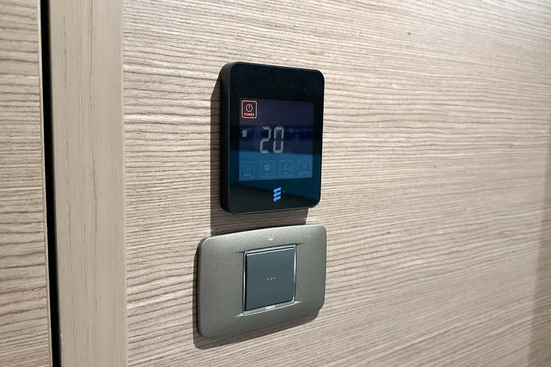 F45079 Yacht Photos Pics Digital thermostat and light switch on wood panel, Princess F45 yacht, 2022 model.