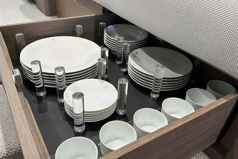 F45079 Yacht Photos Pics Drawer with neatly organized white plates and cups on a Princess F45 yacht, 2022 model.