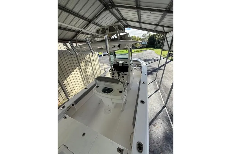  Yacht Photos Pics 2023 Everglades 253 Center Console boat under a metal canopy, showcasing interior layout.