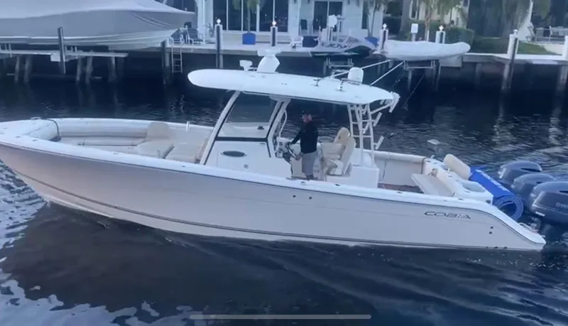  Yacht Photos Pics 2018 Cobia 344 Center Console boat docked in marina, featuring sleek design and triple engines.